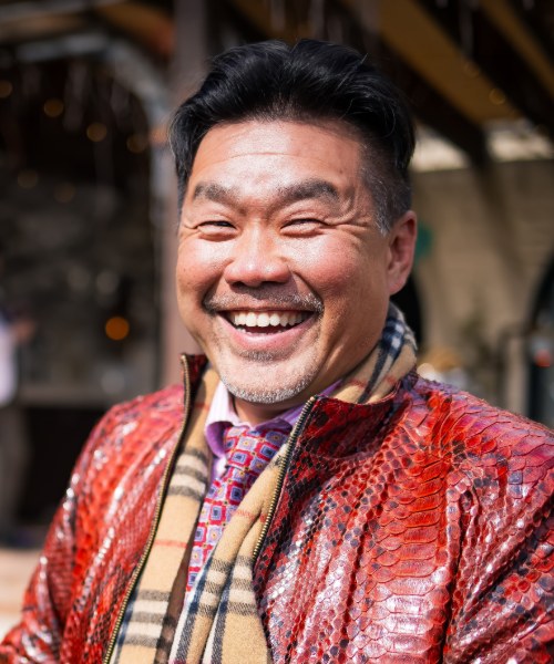 Kai Chang, laughing, in a red python-print jacket